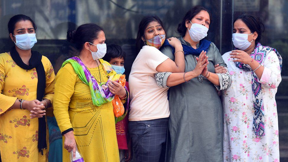 Family members of a person who died of Covid-19 react during a cremation